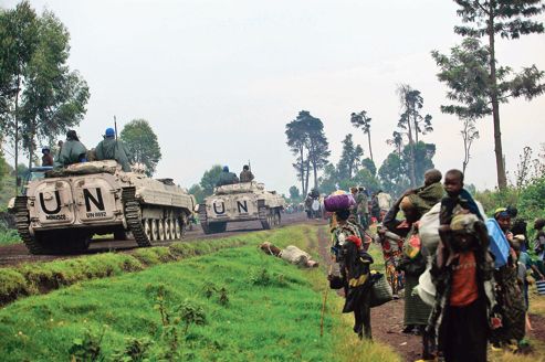 UN armoured vehicles drive past people fleeing renewed fighting between Congolese army and M23 rebels near the eastern Congolese city of Goma